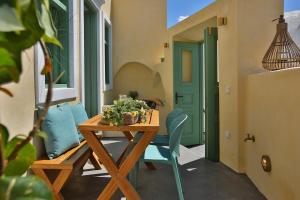 皮尔戈斯Yellow Orchid Cycladic House的一个带木桌和椅子的庭院和一扇绿门
