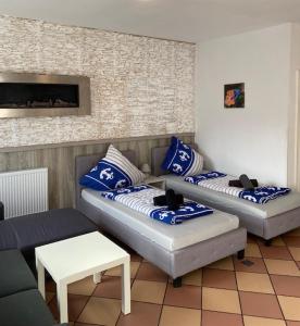 吕贝克吕贝克家庭公寓的客厅设有两张沙发,配有蓝色和白色枕头