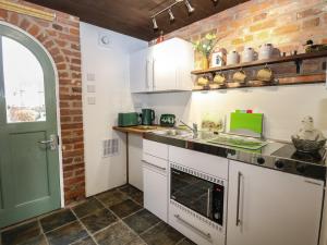费克纳姆The Annexe的厨房配有白色橱柜和绿门