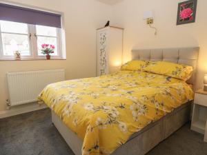 费克纳姆The Annexe的一间卧室配有黄色床、黄色床单和窗户