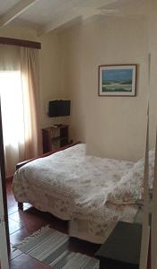阿尔加罗沃阿尔加罗沃卡瓦尼亚斯的奎伦西亚乡村民俗的一间卧室配有一张床和一台电视