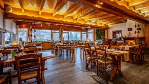 拉布雷斯Hôtel - Restaurant Le Couchetat的餐厅设有木桌、椅子和窗户。