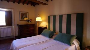 潘札诺勒巴罗别墅酒店的卧室配有一张带两个枕头的大白色床
