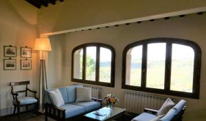 潘札诺勒巴罗别墅酒店的带沙发和2扇窗户的客厅