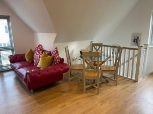萨弗伦沃尔登Debussys Guest House的客厅配有红色的沙发和桌子
