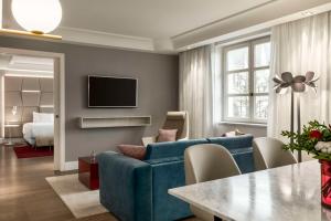 布鲁塞尔布鲁塞尔大萨布隆NH酒店的客厅配有蓝色的沙发和电视