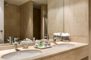 布鲁塞尔布鲁塞尔大萨布隆NH酒店的一间带两个盥洗盆和大镜子的浴室