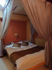 滨松幻想情趣酒店（仅限成人入住）的一间卧室配有两张带窗帘的大床