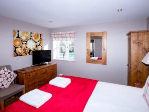 韦尔斯Pass the Keys Tranquil Hideaway in Wells, Somerset - One Bedroom Cottage的一间卧室配有一张带红色毯子的床