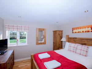 韦尔斯Pass the Keys Tranquil Hideaway in Wells, Somerset - One Bedroom Cottage的一间卧室配有一张带红色毯子的床