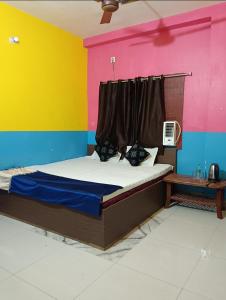 德奥加尔Parinay Vatika Inn的一张位于多彩墙上的床铺