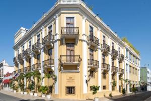 圣多明各GRAN HOTEL EUROPA TRADEMARK COLLECTION by WYNDHAM的街道上带阳台的黄色建筑