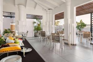 圣多明各GRAN HOTEL EUROPA TRADEMARK COLLECTION by WYNDHAM的用餐室配有餐桌和食物