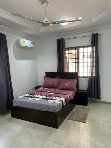 OgbojoWyndham Villa的一间卧室配有一张床和吊扇