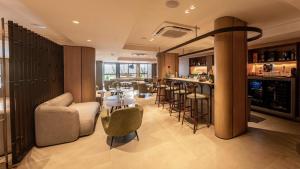 若昂佩索阿HCM - Hotel Corais de Manaira的客房设有带椅子和桌子的酒吧。