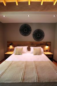 卢汉德库约Heura Petit Hotel的卧室配有一张带白色床单和枕头的大床。