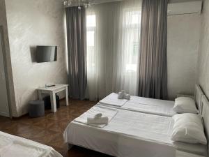 巴统Emilia的酒店客房设有两张床和窗户。
