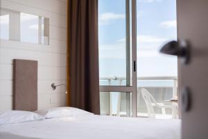 米兰马瑞提那马杰斯酒店的一间卧室设有一张床,享有阳台的景色