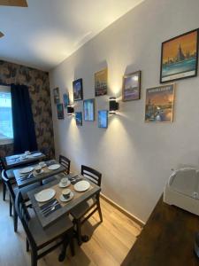 图尔贝特洛酒店的用餐室配有桌椅和墙上的照片