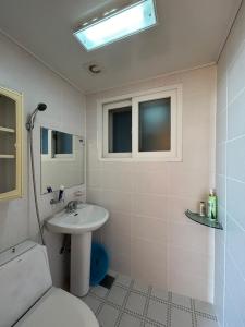 顺天市Sunset Hanok Stay的白色的浴室设有水槽和卫生间。