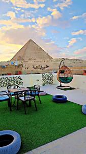 开罗Solima pyramids inn的一个带桌椅和金字塔的庭院