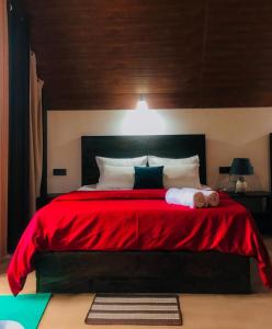 纳拉坦尼亚Water Side Residence的一间卧室配有一张带红色毯子的大床
