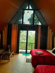 纳拉坦尼亚Water Side Residence的一间卧室设有红色的床和大窗户