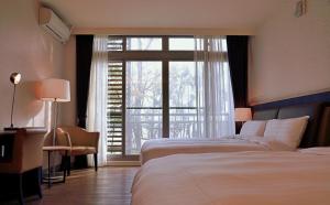 鱼池乡日月潭竹石园生态渡假会馆的酒店客房设有两张床和大窗户。