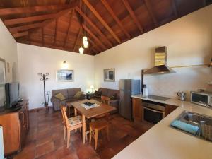 埃尔帕索卡萨巴戎度假屋的厨房以及带桌子和沙发的客厅。