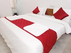 埃尔加德Skylight Residency Yercaud的两张带红白毯子和枕头的床
