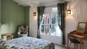 圣安尼Les Coulirooms - Suite avec jacuzzi et grande terrasse的一间卧室配有一张床、一个窗口和一张书桌