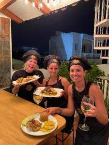 卡塔赫纳Life is Good Cartagena Hostel的一群妇女拿着食物和葡萄酒盘
