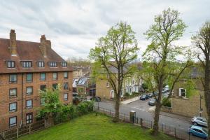 伦敦Lovely Apartment in Victoria Park Village的享有拥有建筑和树木的城市街道的景色