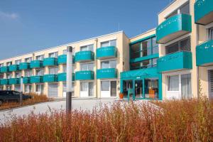 埃尔丁Apartments in Erding - Oberbayern 36757的公寓大楼设有蓝色的阳台和停车场