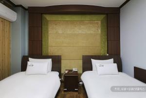 顺天市Hyatt Motel的两张睡床彼此相邻,位于一个房间里