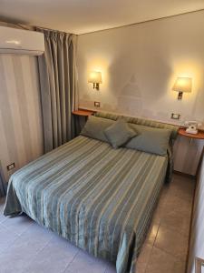 罗马太平洋酒店的一间卧室配有带条纹被子的床