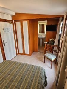 罗马太平洋酒店的一间卧室配有一张床、一把椅子和一个水槽