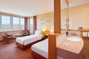 韦斯特尔堡Lindner Hotel Wiesensee的酒店客房设有两张床和盥洗盆