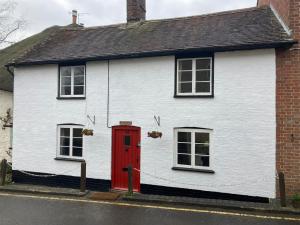 斯特明斯特牛顿Nutshell的白色的房子,有红色的门和两个窗户