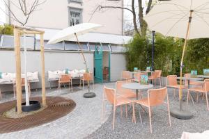 苏黎世Boutique & Art Hotel Helvetia的一个带桌椅和遮阳伞的庭院。