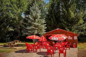 Saint-Chéronlocation mobil-home的一组红色的椅子和桌子以及雨伞