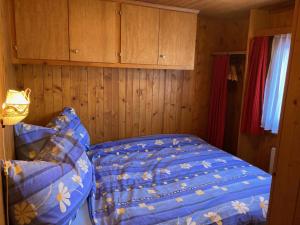 RosswaldChalet Alphütte的一间卧室配有一张带蓝色棉被的床