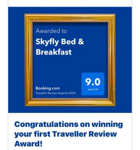 曼齐尼Skyfly Bed & Breakfast的蓝墙上金色画框的照片