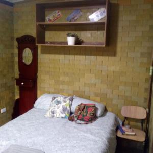 圣弗朗西斯科Colibrí的卧室内的一张带枕头的床铺和时钟
