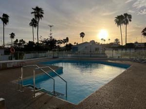 马斯帕洛马斯Relaxing Bungalow Playa del Inglés的一座享有日落美景的大型游泳池