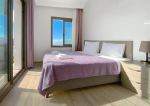 伊兹密尔Azize Palas Apart Otel的一间卧室配有一张大床和紫色毯子