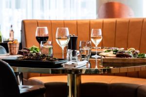 切尔滕纳姆切尔滕纳姆希尔顿逸林酒店的一张桌子,上面放着两盘食物和酒杯