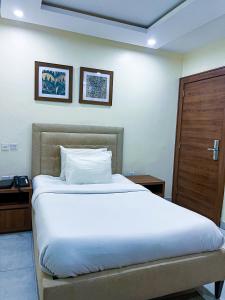 阿布贾Plush Hotel,Abuja的卧室配有一张白色大床和木门
