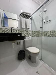 圣路易斯Mais Hotel Express的白色的浴室设有卫生间和玻璃淋浴间。