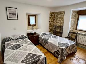 Villar de HuergoLa Casina de Villar的一间卧室设有两张床和窗户。